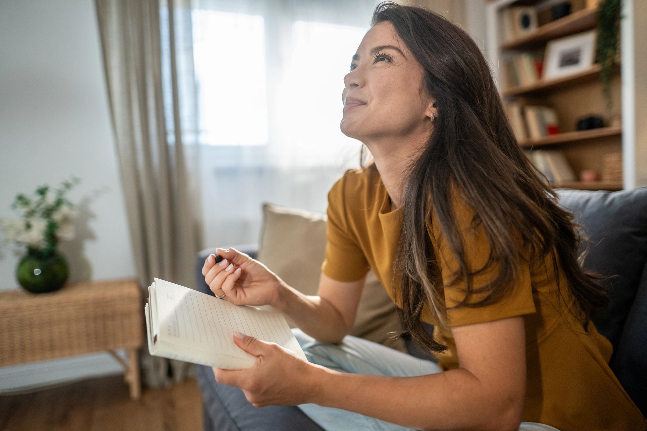 Person journaling in a calm, sunlit living room